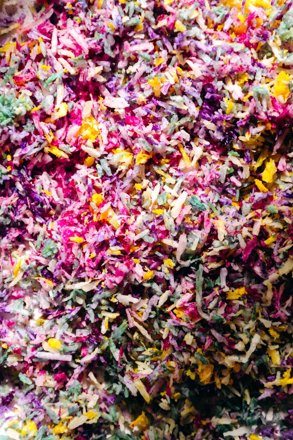 Vegan Sprinkles | DIY Sugar Free Recipe Close-up of colorful homemade coconut sprinkles in pink, purple, yellow, and green, naturally dyed with fruit and plant powders