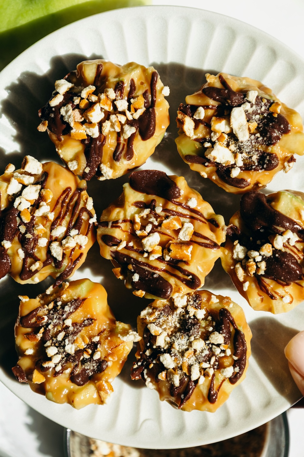 overhead plate of caramel apple pretzel bites held in hand